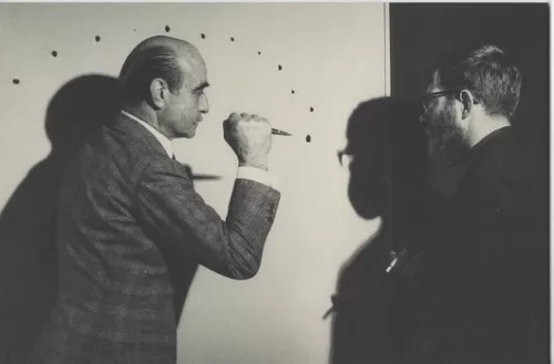 Lucio Fontana mentre realizza Le Jour (1962) presso la casa del collezionista belga Louis Bogaerts. Il pittore Jef Verheyen assiste all’azione filmata da Bogaerts e trasmessa il 3 dicembre 1962 dalla Radio Télévision Belge Francophone. Foto Filip Tas.